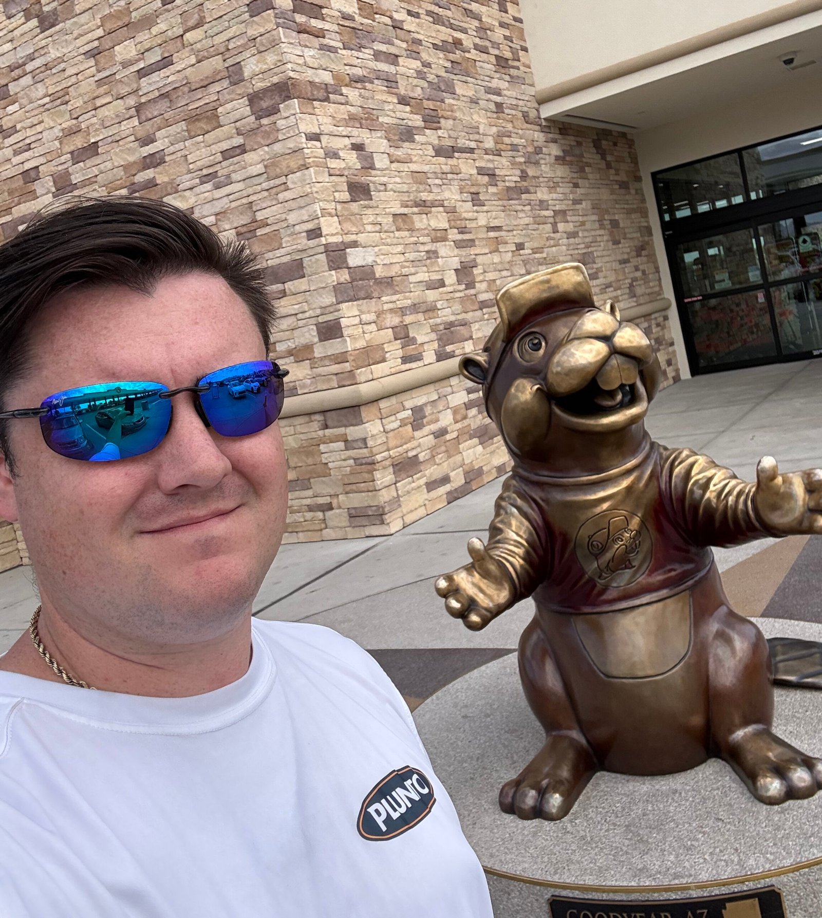 Plunto at Buc-ee's Goodyear beside the Buc-ee beaver statue.